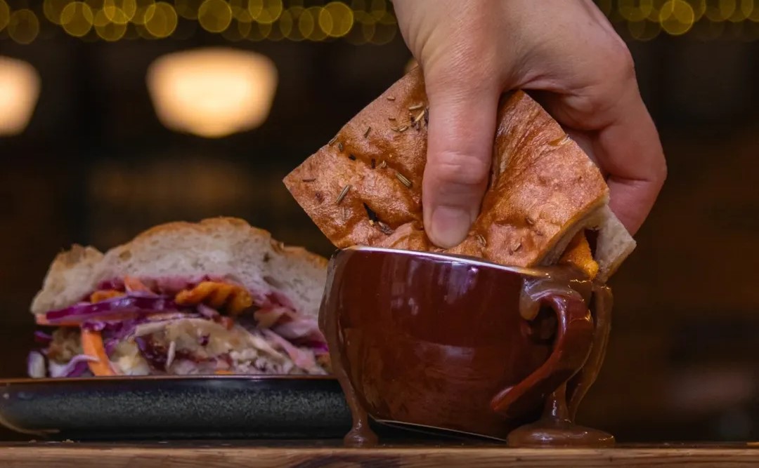Shed Christmas Toastie being dunked into a mug of gravy